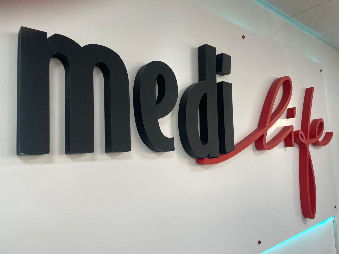 L'insegna tridimensionale Medilife, con «medi» in nero e «life» in rosso corsivo